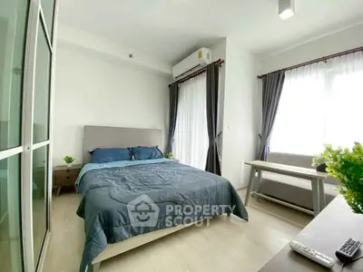 Modern bedroom with natural light, stylish furnishings, and cozy ambiance in a contemporary apartment.
