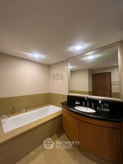 Spacious bathroom with elegant bathtub and modern fixtures in a luxurious home.