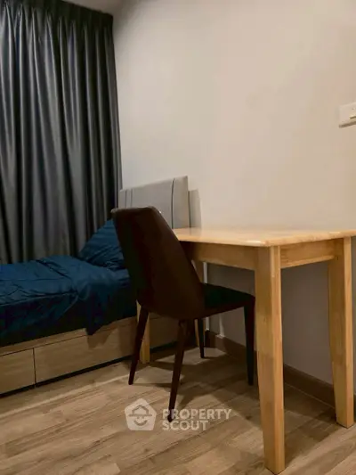 Cozy bedroom with wooden desk and comfortable bed, ideal for a restful retreat.