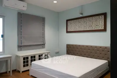 Modern bedroom with stylish decor and natural light, featuring a comfortable bed and elegant furnishings.