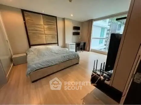 Spacious modern bedroom with large window and stylish decor in a luxury apartment.