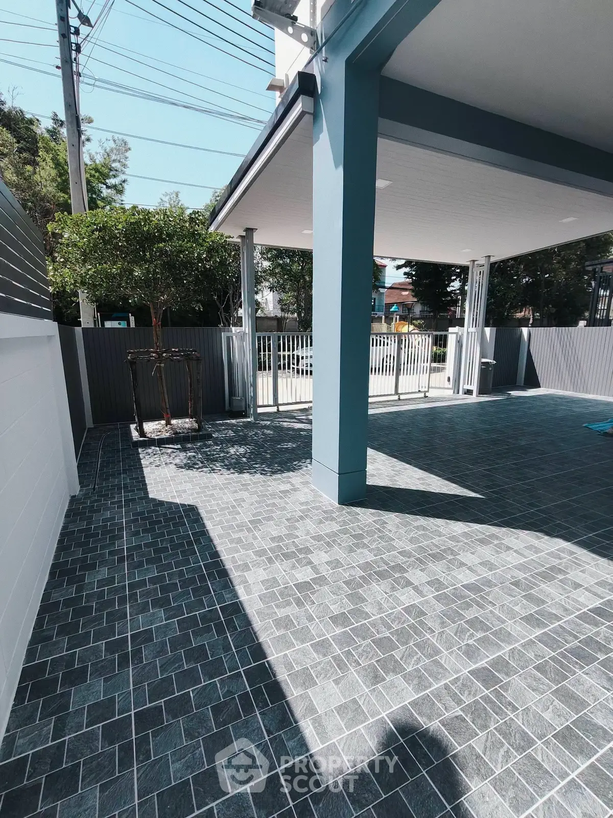 Spacious outdoor patio with modern tiled flooring and partial roof cover, ideal for relaxation and gatherings.