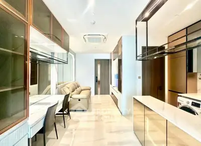 Modern living room with sleek design, featuring a cozy sofa, dining area, and built-in storage.