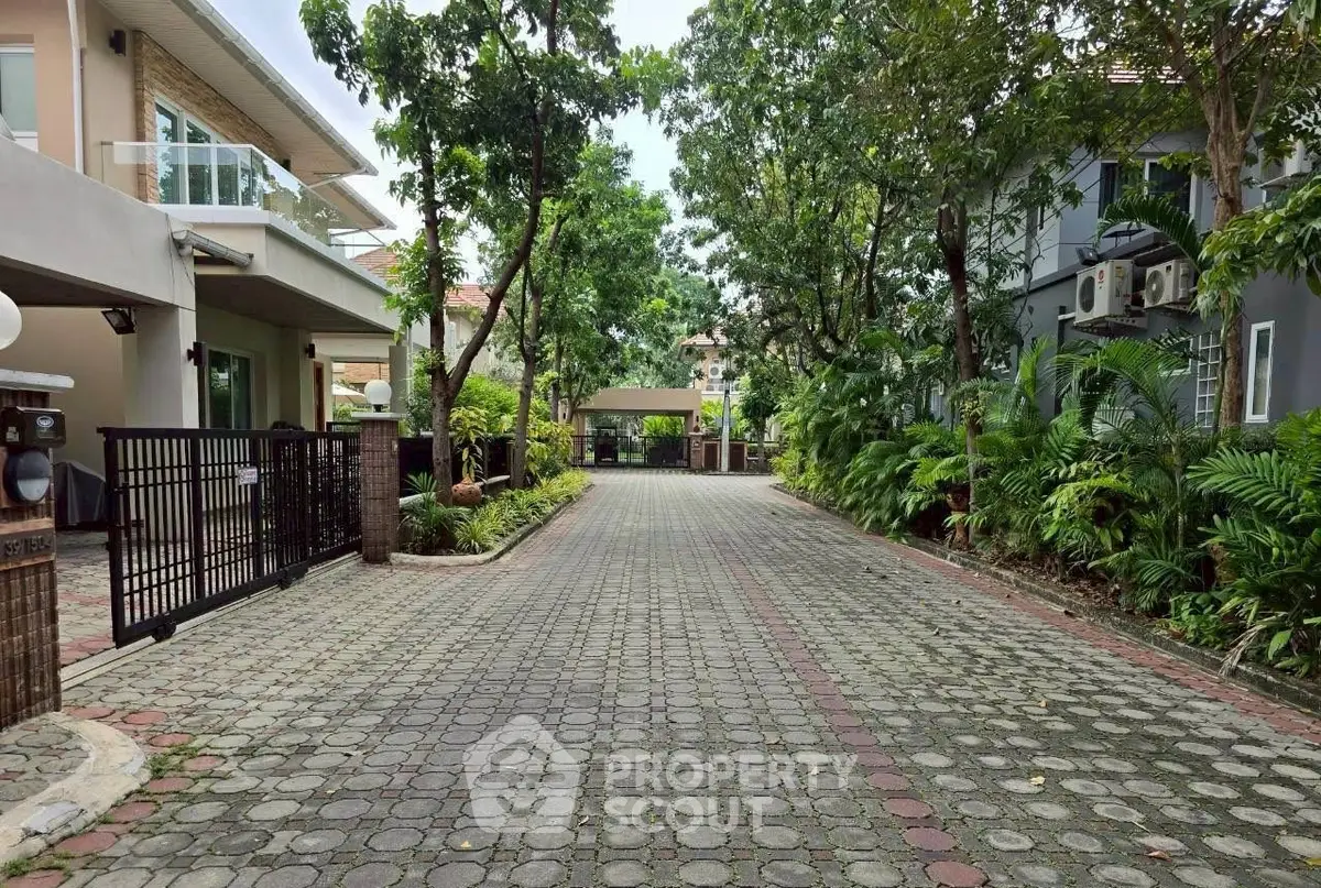 Charming residential driveway with lush greenery and modern homes