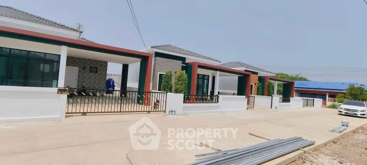 Modern single-story houses with sleek design and spacious driveways in a serene neighborhood.