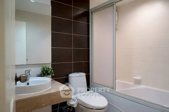 Modern bathroom with sleek design, featuring a bathtub and stylish fixtures.