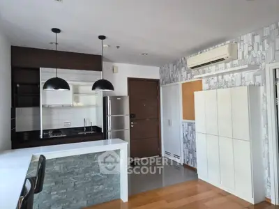 Modern kitchen with sleek design, featuring a breakfast bar, stainless steel appliances, and stylish lighting.