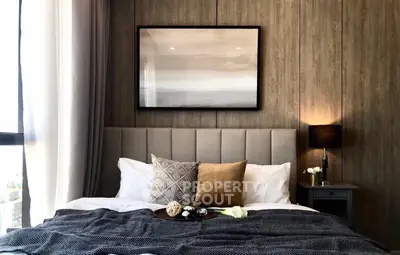 Luxurious bedroom with elegant decor and cozy ambiance, featuring plush bedding and stylish artwork.