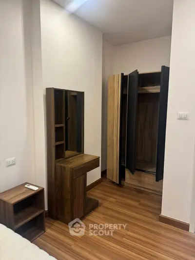 Modern bedroom with sleek wooden furniture and open wardrobe