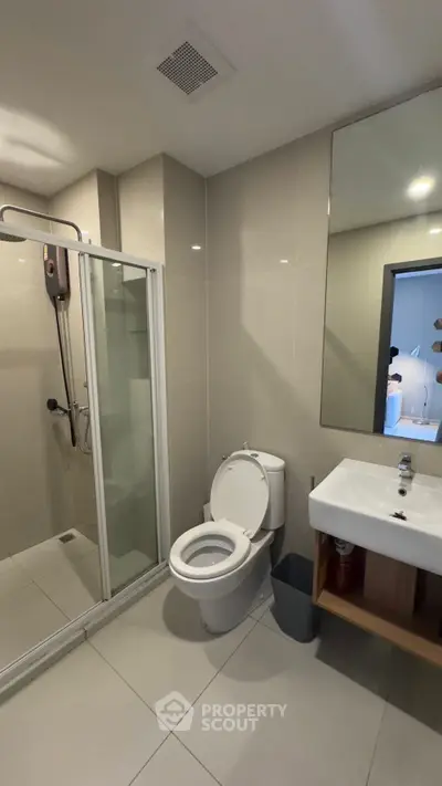 Modern bathroom with shower and sleek fixtures in a contemporary apartment.