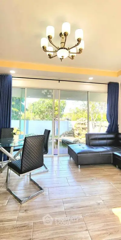 Spacious living room with modern furniture and large windows overlooking a lush garden.