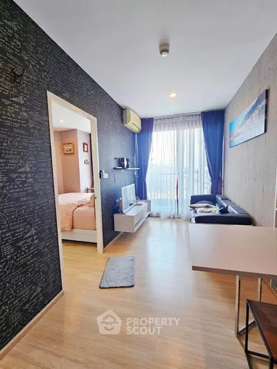 Modern living room with stylish decor and natural light, featuring a cozy bedroom view.