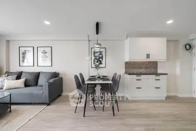 Modern open-plan living room with stylish dining area and sleek kitchen design.