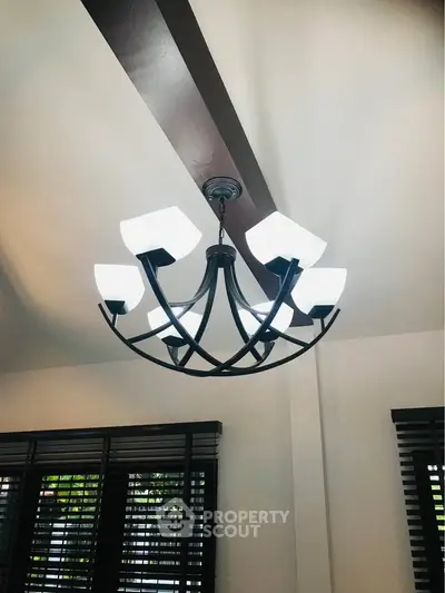 Elegant modern chandelier in a stylish living room with natural light.