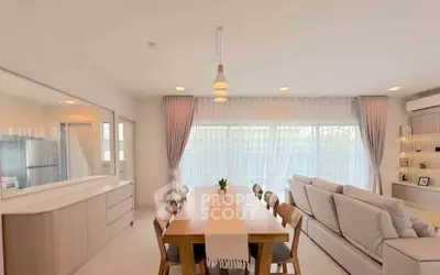 Spacious open-plan living and dining area with modern decor and natural light.
