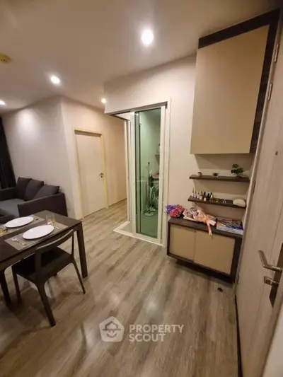 Modern apartment interior with stylish dining area and cozy living room, featuring elegant wooden flooring.