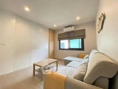 Modern living room with cozy sofa and natural light, perfect for relaxation.