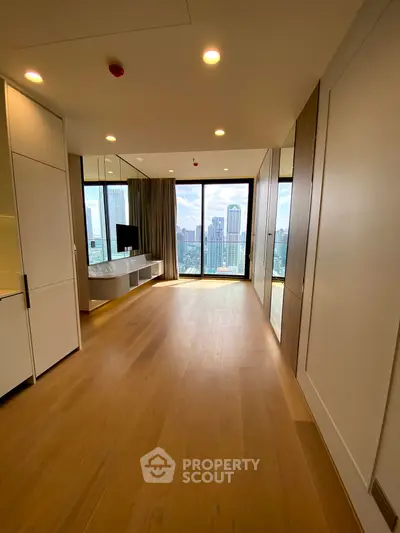 Spacious modern living room with stunning city view and floor-to-ceiling windows.