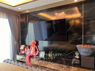 Luxurious living room with marble wall and modern decor, featuring a sleek TV and plush seating.