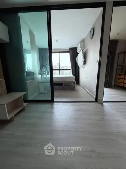 Modern apartment interior with glass partition and bedroom view