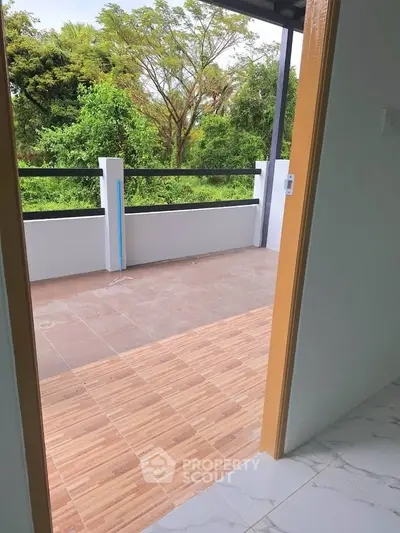 Spacious balcony with scenic green view, perfect for relaxation and outdoor enjoyment.