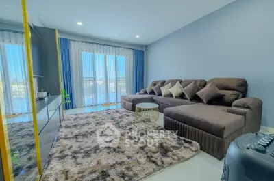 Spacious living room with plush sectional sofa and large windows for natural light.