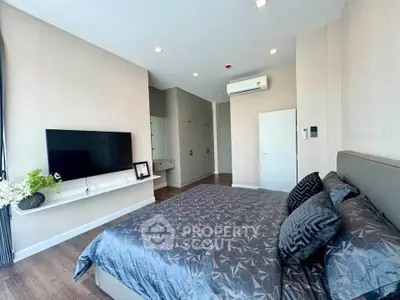 Modern bedroom with stylish decor and wall-mounted TV in a bright apartment.