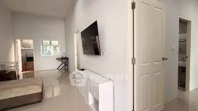 Modern living room with sleek TV setup and cozy sofa, perfect for relaxation.