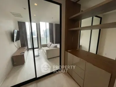 Modern living room with glass partition and city view, featuring sleek furniture and ample natural light.