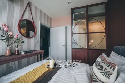 Chic bedroom with stylish decor, featuring a cozy bed, decorative pillows, and elegant wall accents.
