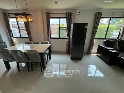 Modern dining area with elegant lighting and large windows in a stylish home