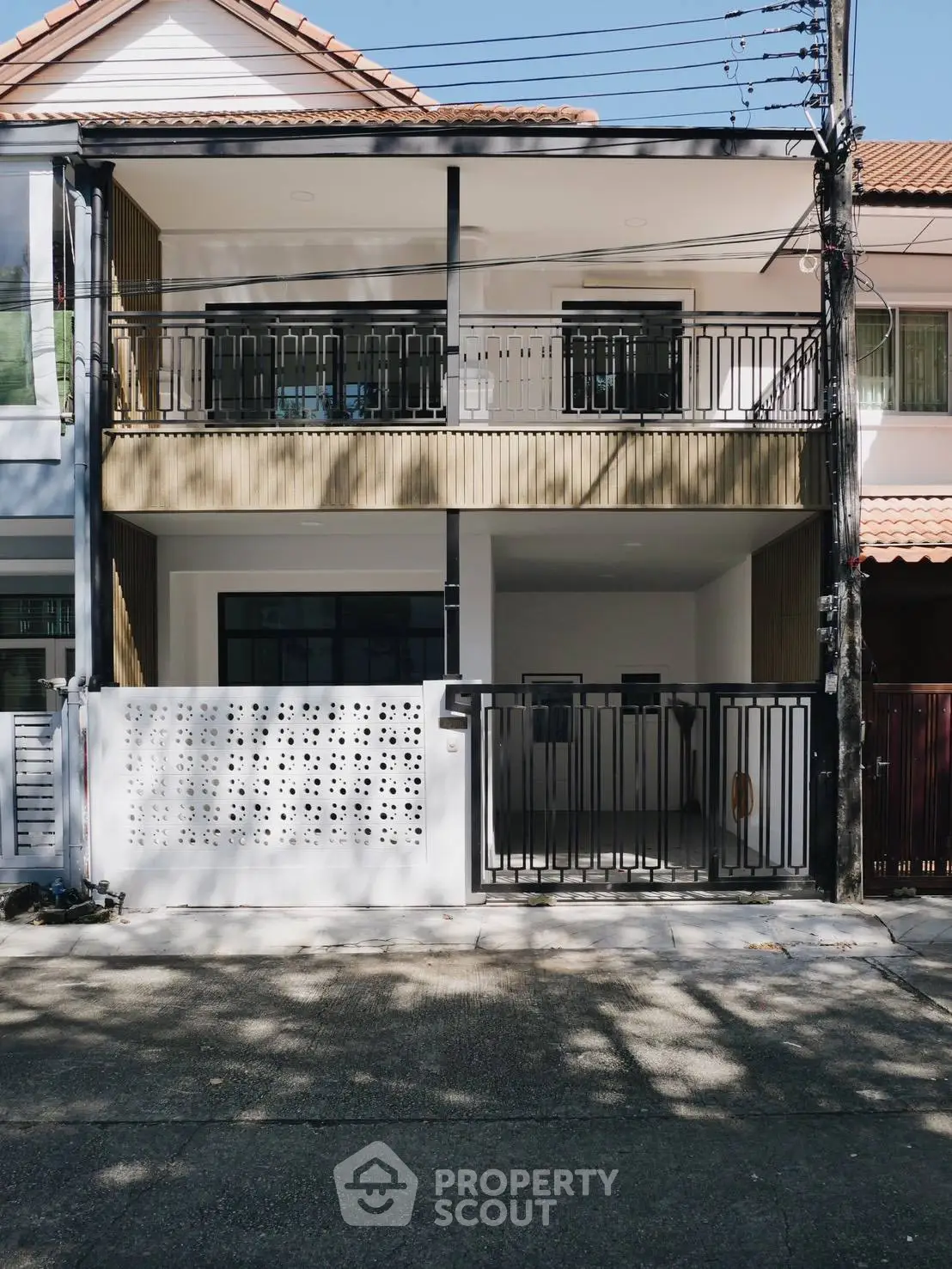 Modern two-story townhouse with balcony and gated entrance