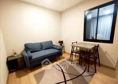 Cozy living room with modern sofa and dining table, perfect for small apartments.
