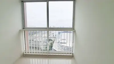Bright room with large window offering panoramic city view, perfect for modern living.