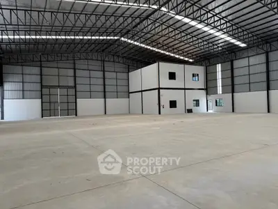Spacious industrial warehouse with high ceilings and ample natural light, perfect for storage or manufacturing.
