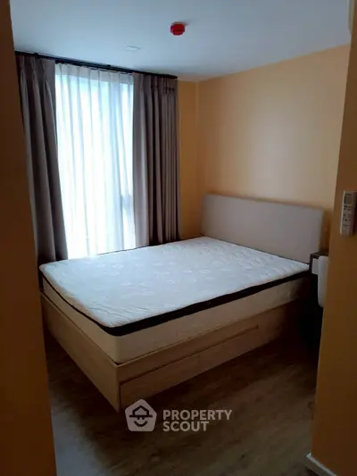 Cozy bedroom with natural light and modern furnishings, perfect for relaxation and comfort.