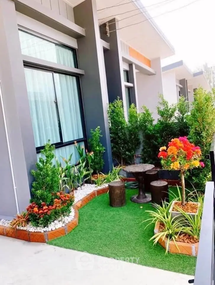 Charming garden view with vibrant plants and cozy seating area in modern home exterior.