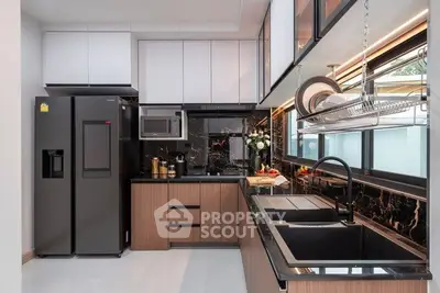 Modern kitchen with sleek black appliances and elegant cabinetry