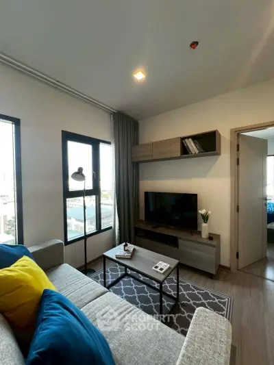Modern living room with stylish decor and large windows offering natural light.