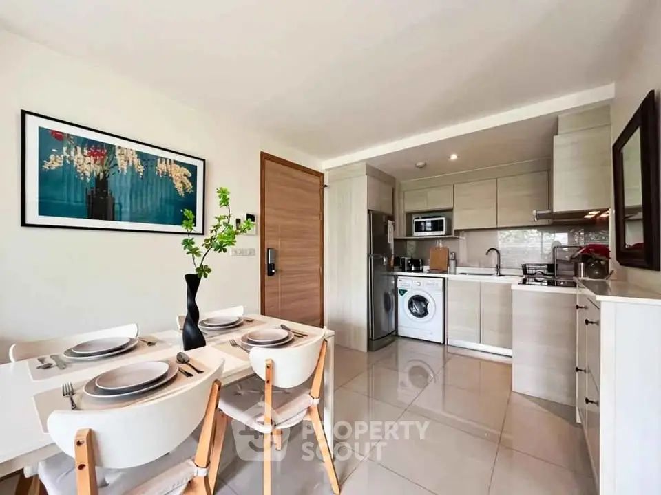 Modern kitchen with dining area, featuring sleek appliances and stylish decor.