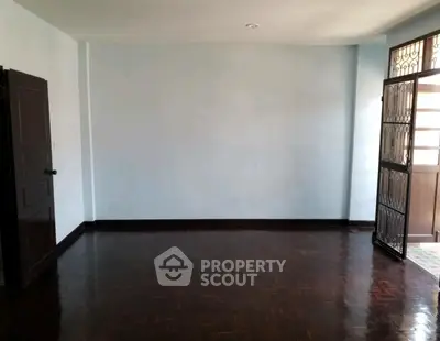 Spacious empty room with polished wooden floors and natural light