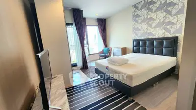 Modern bedroom with stylish decor and city view, featuring a comfortable bed and sleek furniture.