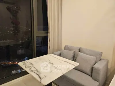 Cozy living room corner with marble table and city view, perfect for relaxation.