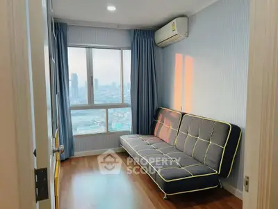 Cozy room with city view, featuring a modern sofa and large window for natural light.