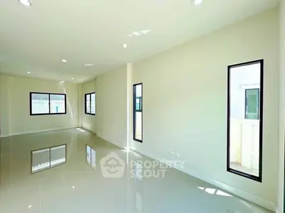 Spacious and bright living room with large windows and glossy floors