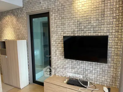 Modern living room with textured wall and mounted TV in stylish apartment