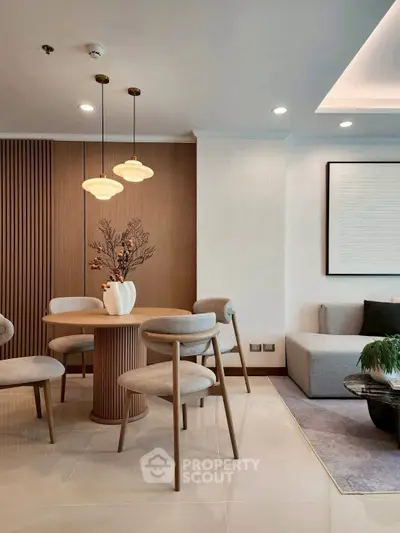Elegant modern living room with stylish dining area and cozy seating, featuring chic lighting and contemporary decor.