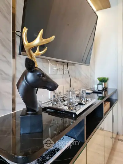 Modern living room with stylish decor and mounted TV, featuring elegant marble accents and sleek furnishings.