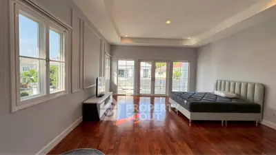 Spacious bedroom with hardwood floors and large windows offering natural light