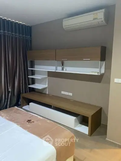 Modern bedroom with sleek storage and air conditioning unit